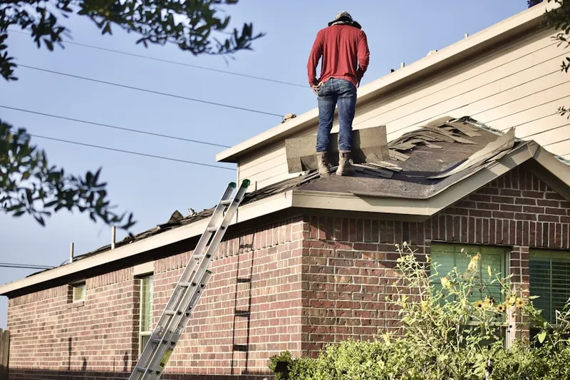 Professional roofer working on a residential roof in Heritage West